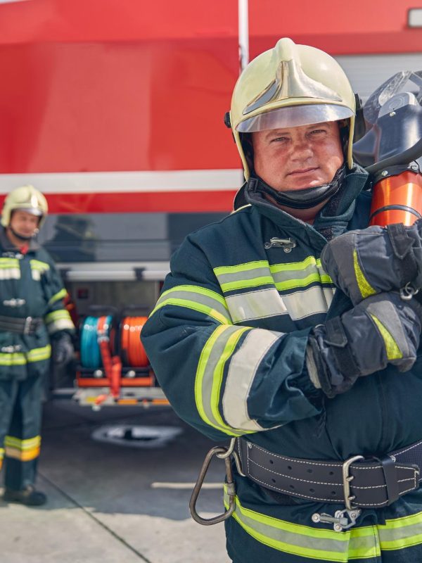 portrait-of-confident-fireman-with-male-colleagues-2023-11-27-04-49-41-utc